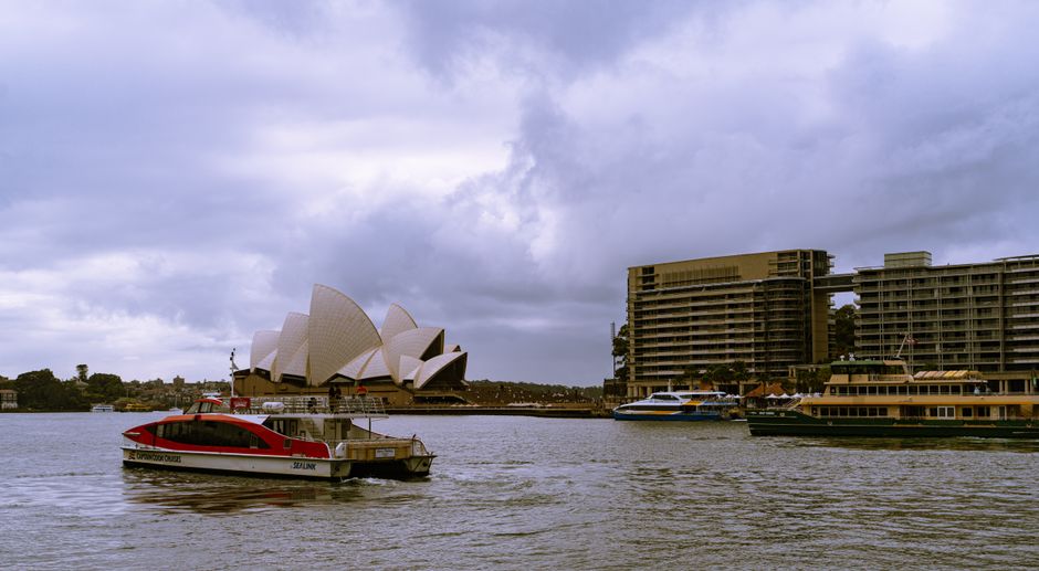 australia — Scenic view of Sydney Opera House and bustling harbor in cloudy weather, New South Wales, Australia.
