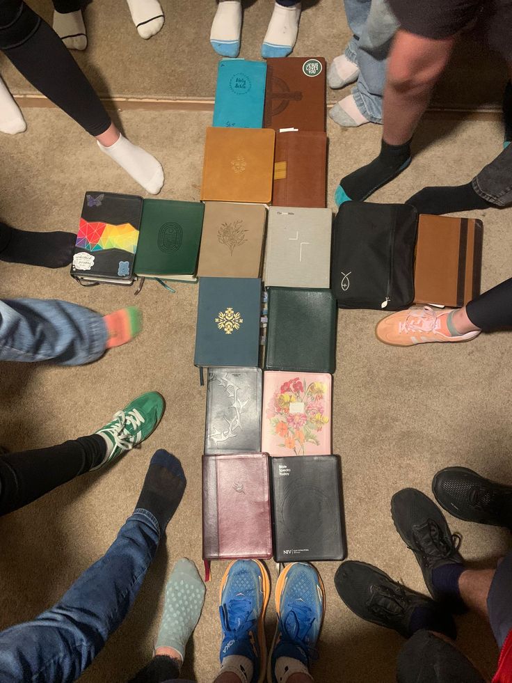 Bibles arranged in a cross on the floor surrounded by campers' feet