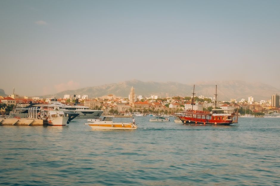 croatia — Boats sail near the scenic Split harbor under a clear sky, showcasing Croatia's vibrant coastal life