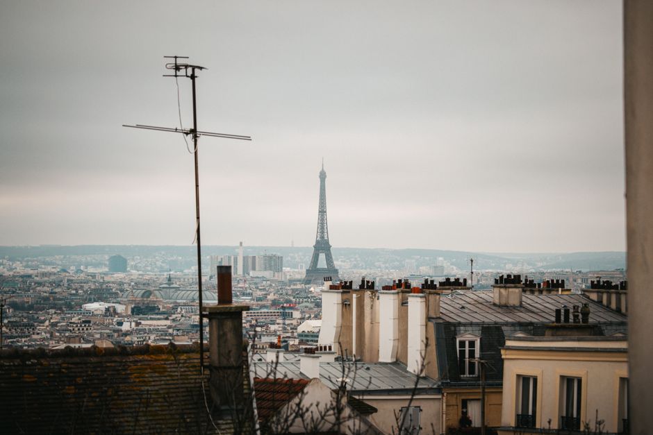 france — A panoramic view of Paris skyline featuring the Eiffel Tower during winter, showcasing iconic roofto