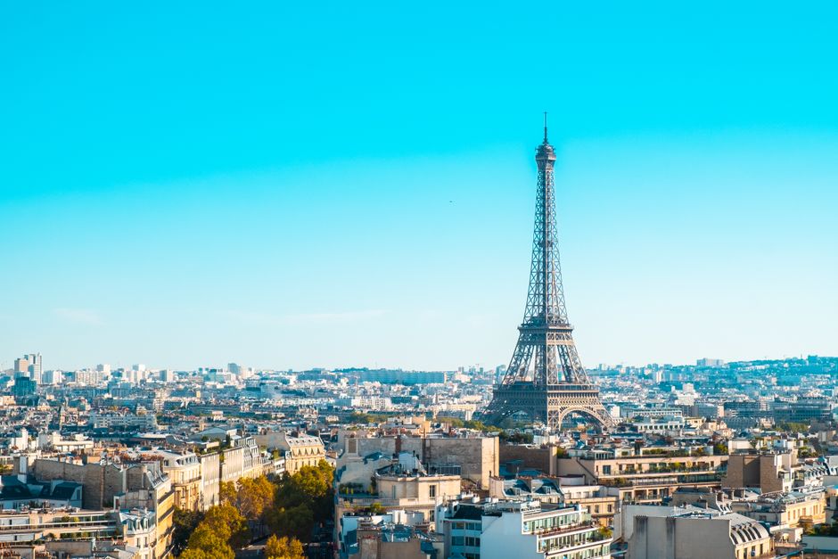france — Eiffel Tower overlooking the cityscape of Paris under clear blue skies.