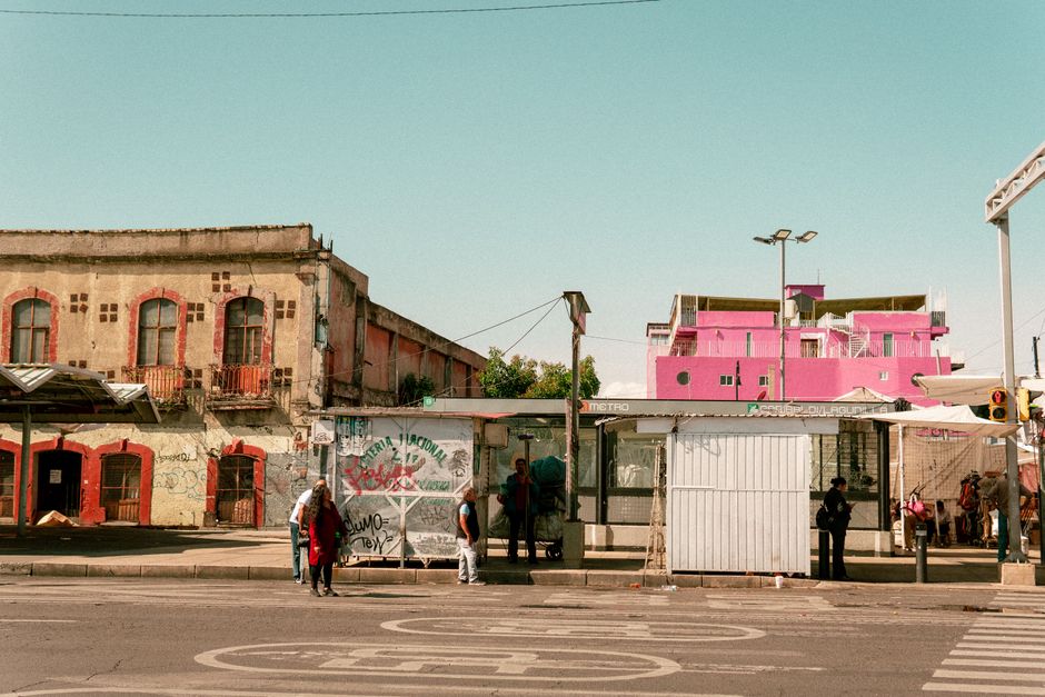 mexico — Bus stop scene with colorful buildings in Ciudad de México, showcasing local urban life.
