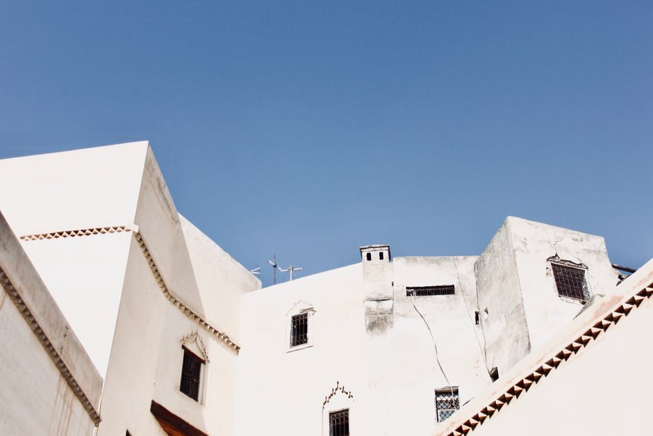 White buildings against a clear blue sky in the historic city of Fès, Morocco.