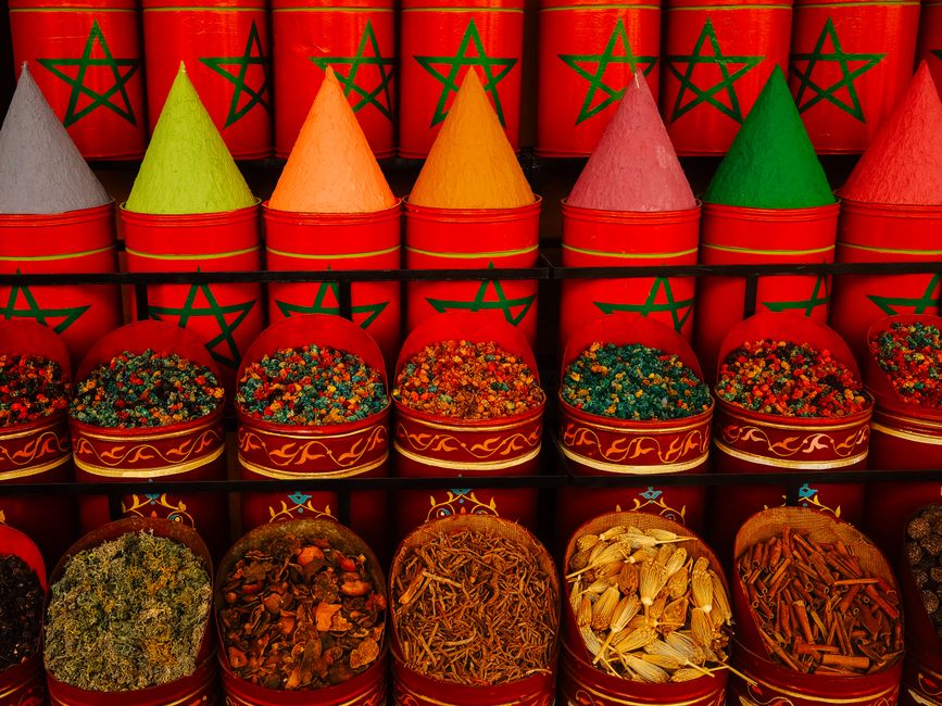 morocco — Vibrant display of traditional spices in Moroccan market with colorful cones and aromatic herbs.