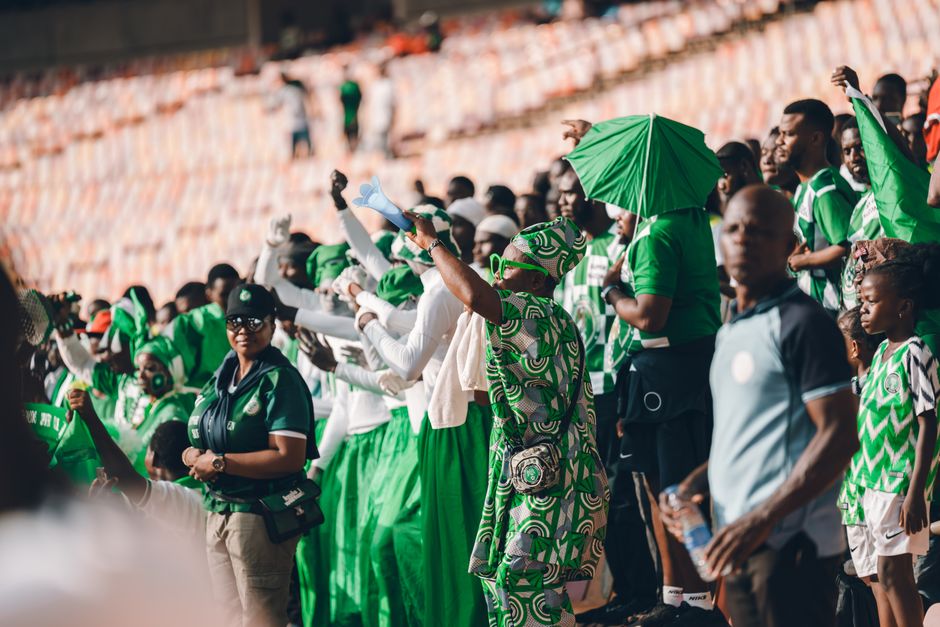 nigeria — Energetic crowd of Nigerian sports fans wearing green, cheering during a stadium event.