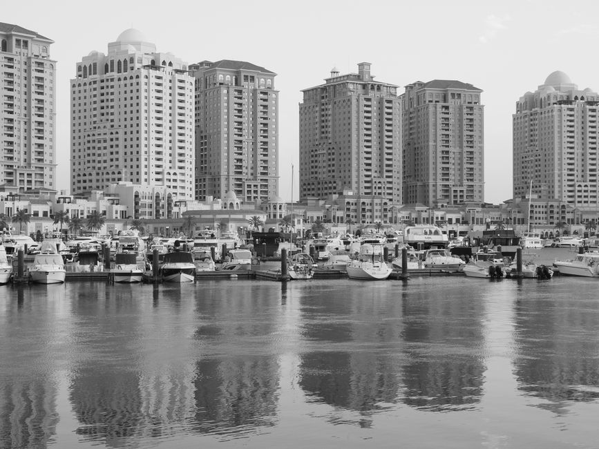 qatar — Elegant monochromatic shot of Doha's skyline with yachts at harbor, exuding a serene waterfront vibe