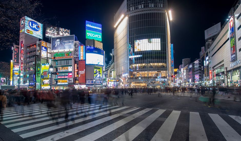 Experience the vibrant energy of Shibuya Crossing in Tokyo at night, with bustling crowds and colorful neon li